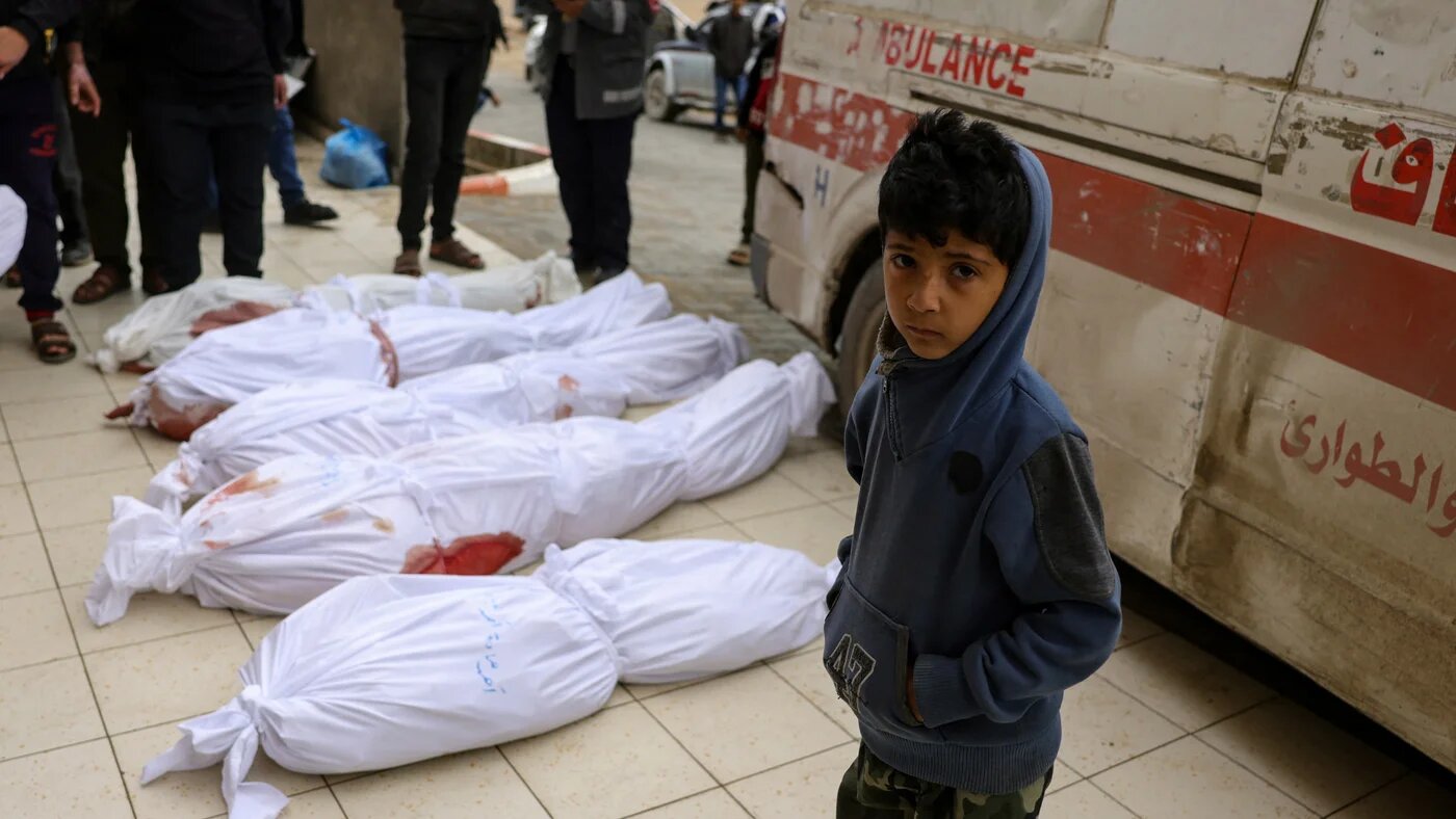 A Palestinian child looks on as bodies of victims of Israeli overnight air strikes in northern Gaza lie on the ground in front of the Indonesian Hospital in Beit Lahia on 20 March 2025 (AFP/Bashar Taleb)