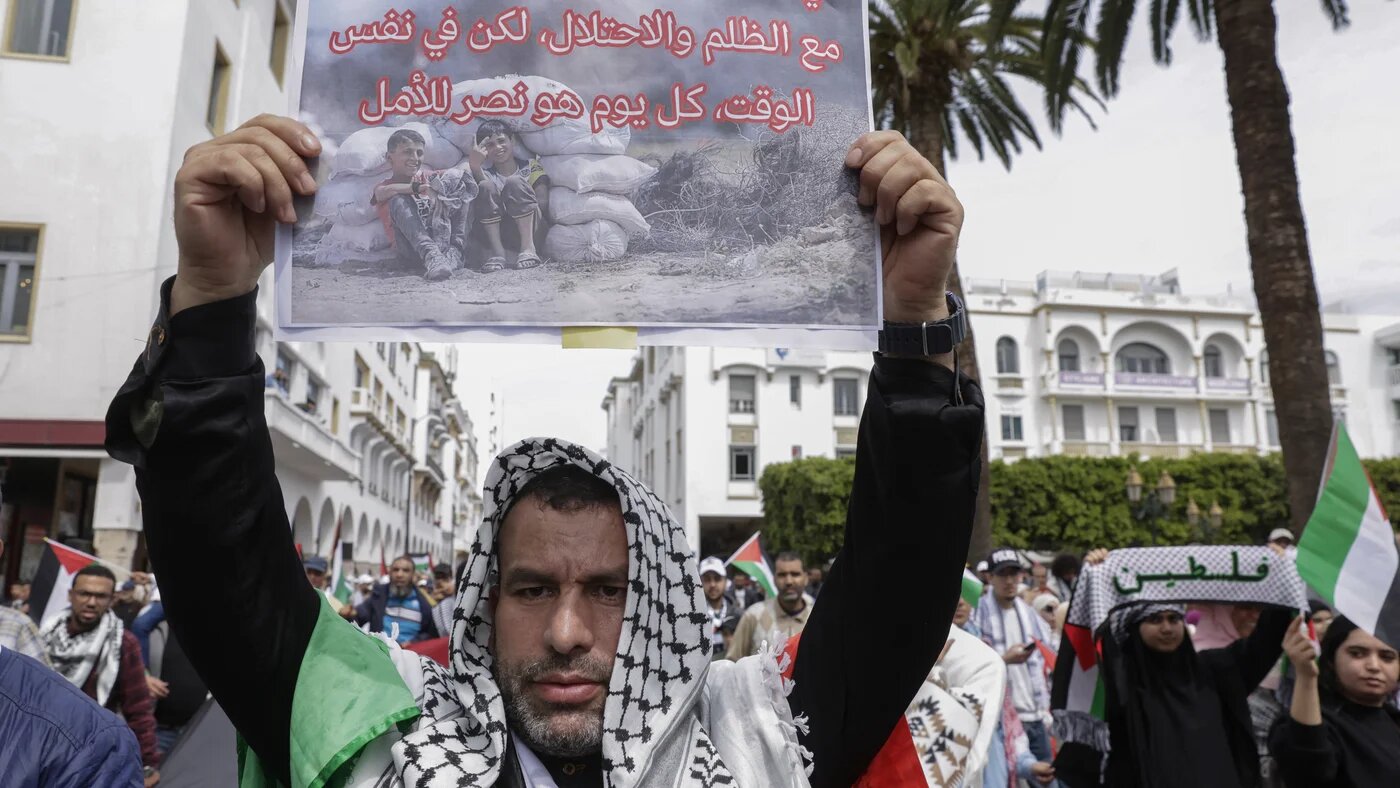 A protester holds a placard reading "In Gaza, every day is a battle with injustice and occupation, but also a victory for hope" at a march in Rabat against Morocco's normalisation with Israel, on 6 April 2025 (Abdel Majid Bziouat/AFP)