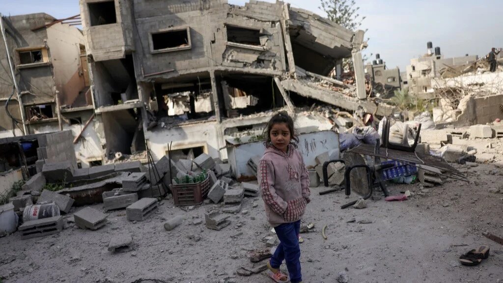 A Palestinian girl walks past a destroyed building following overnight Israeli strikes on Jabalia in the northern Gaza Strip on 16 April (AFP/Bashar Taleb)