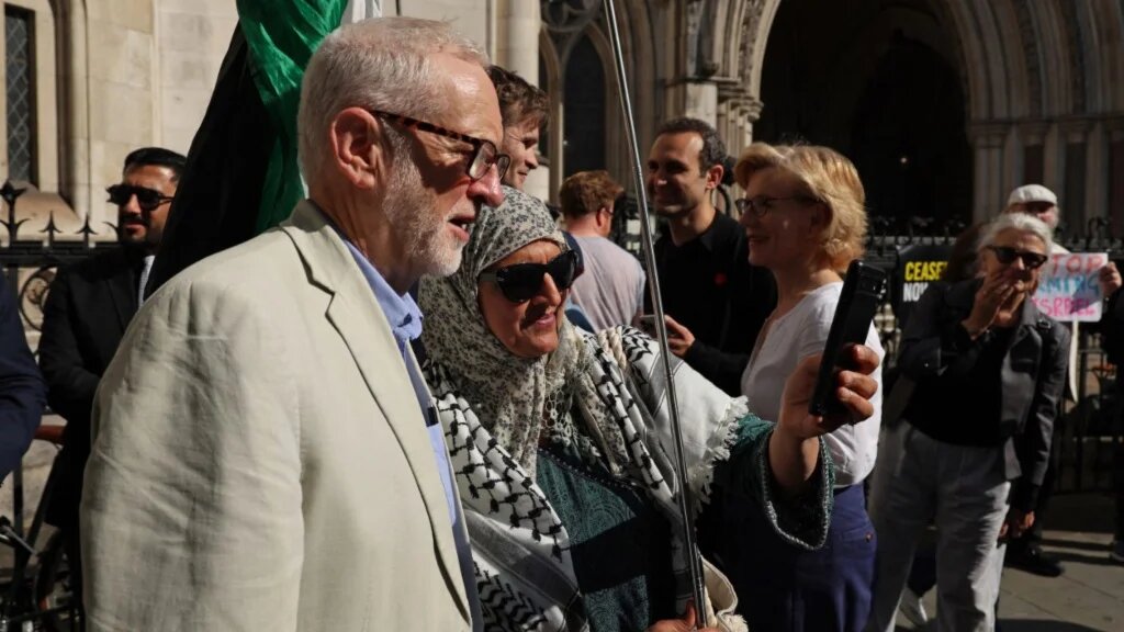 Former Labour leader Jeremy Corbyn poses for a photo outside the Royal Courts of Justice in central London on 13 May 13 2025 (AFP)