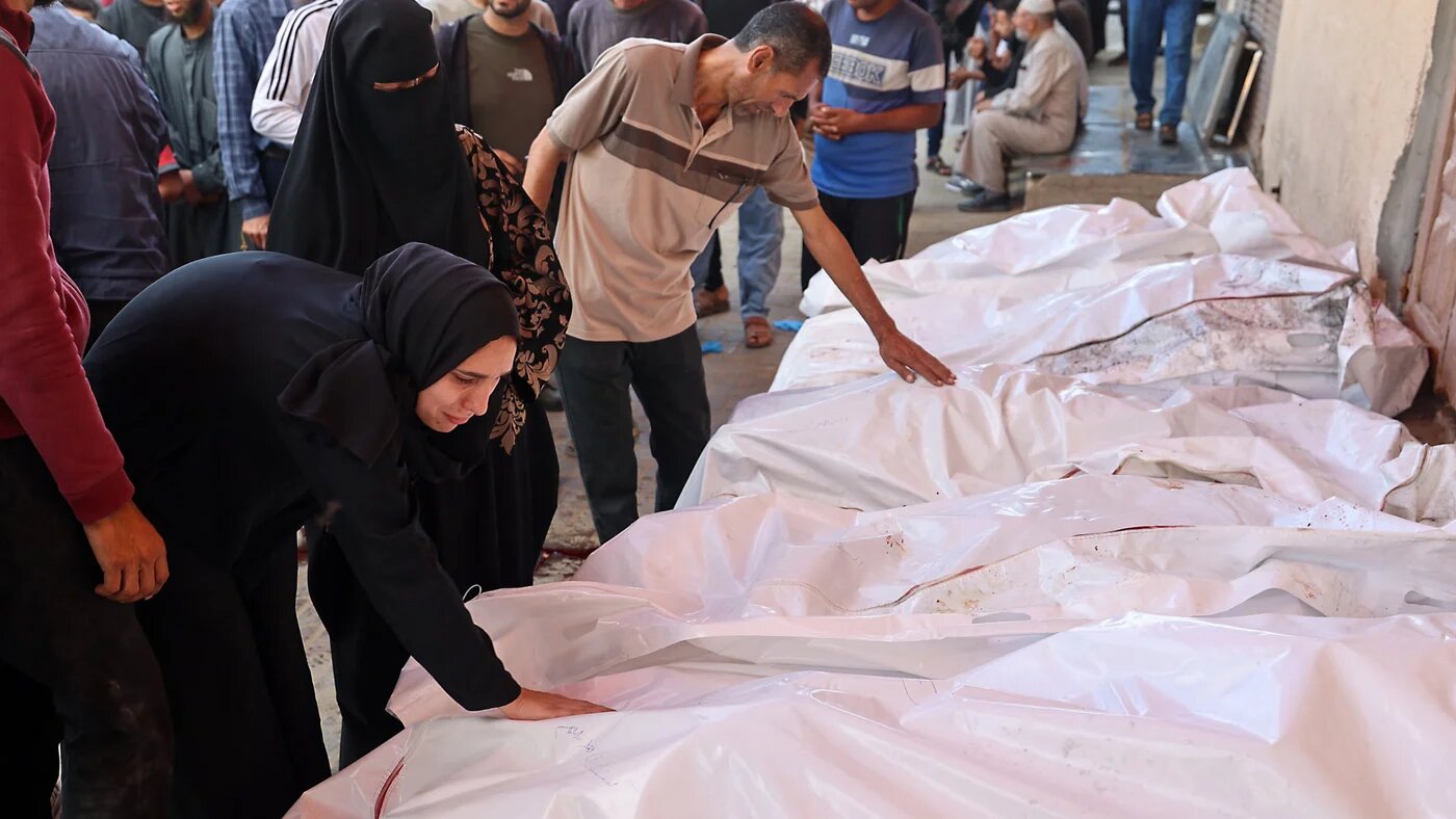 Palestinians mourn over the bodies of those killed in Israeli air strikes, at al-Aqsa Martyrs Hospital in Deir el-Balah, central Gaza, on 20 May 2025 (Eyad Baba/AFP)