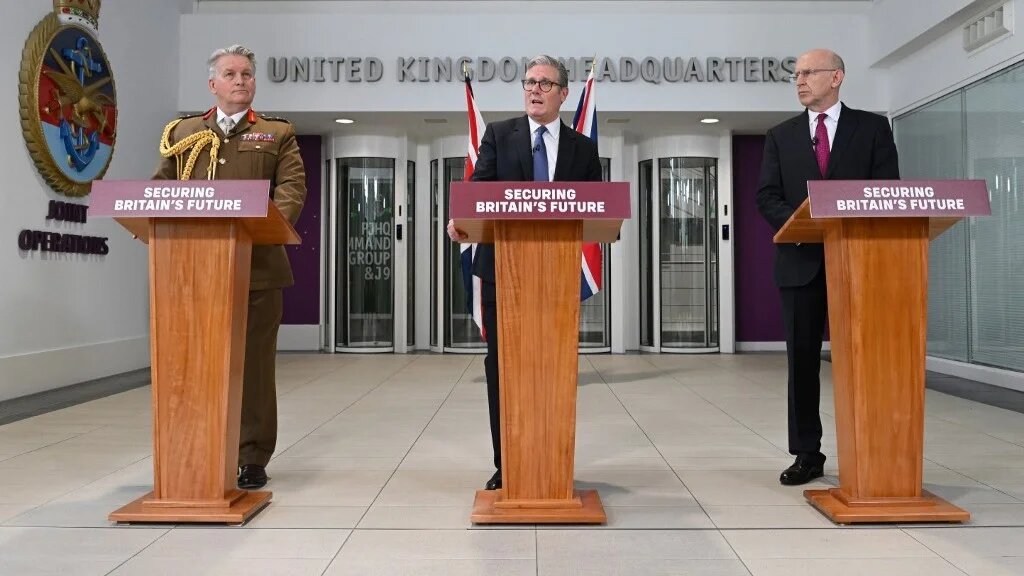Britain's Prime Minister Keir Starmer (C) flanked by Commander of Strategic Command, General James Hockenhull (L) and Britain's Defence Secretary John Healey (R), announces agreement to return the remote Chagos Islands to Mauritius in return for continued use of a key military base in May (AFP)