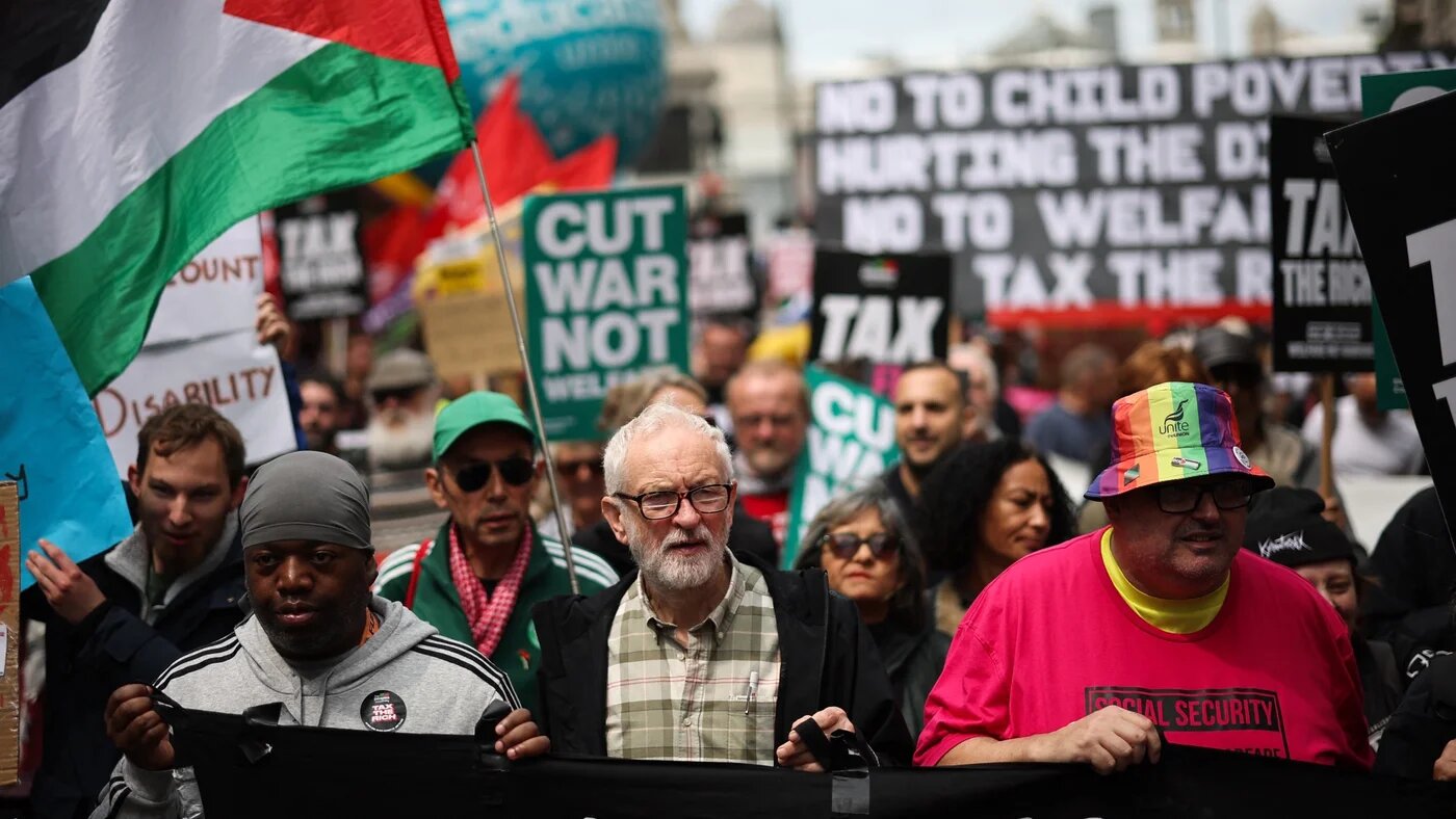 Independent MP Jeremy Corbyn (centre) holds a banner during the 'No More Austerity 2.0' march in central London on 7 June 2025, organised by the People's Assembly Against Austerity (Henry Nicholls/AFP)