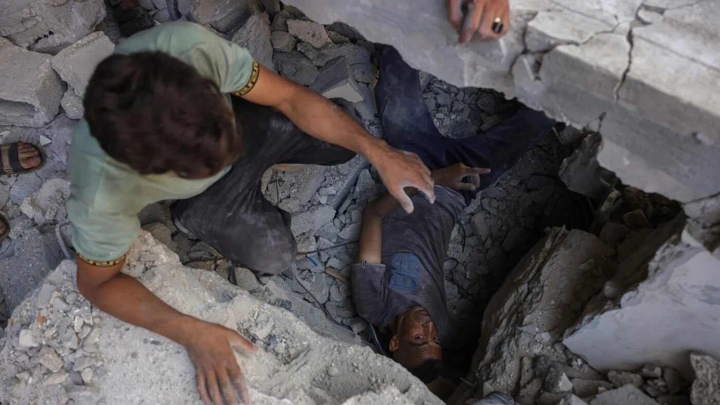 Palestinians search for survivors in the rubble of a building in Gaza City that was targeted in an Israeli strike on 26 July 2025 (AFP/Bashar Taleb)