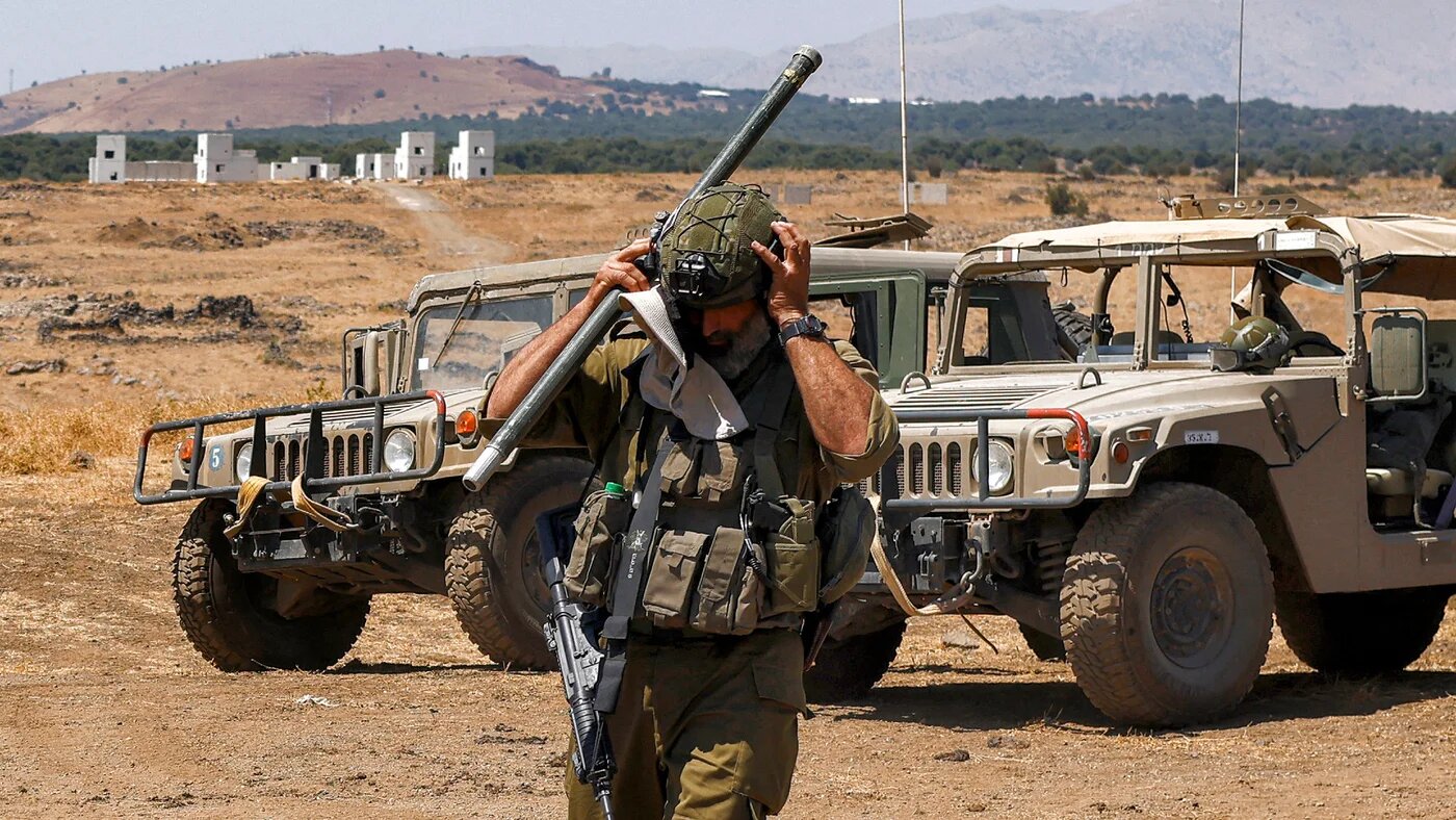 An Israeli soldier adjusts his helmet in the Israeli-occupied Golan Heights near the Syrian border, amid Israel’s expanding military presence in southern Syria, on 8 July 2025 (Jalaa Marey/AFP)