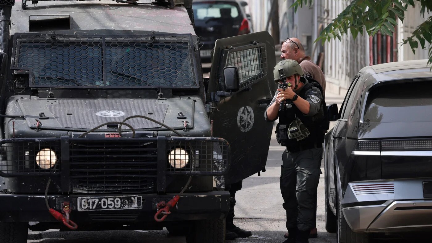 An Israeli soldier aims his weapon during a raid at the Balata refugee camp in the occupied West Bank, where at least 968 Palestinians have been killed since the Gaza war began, on 11 August 2025 (Jaafar Ashtiyeh/AFP)