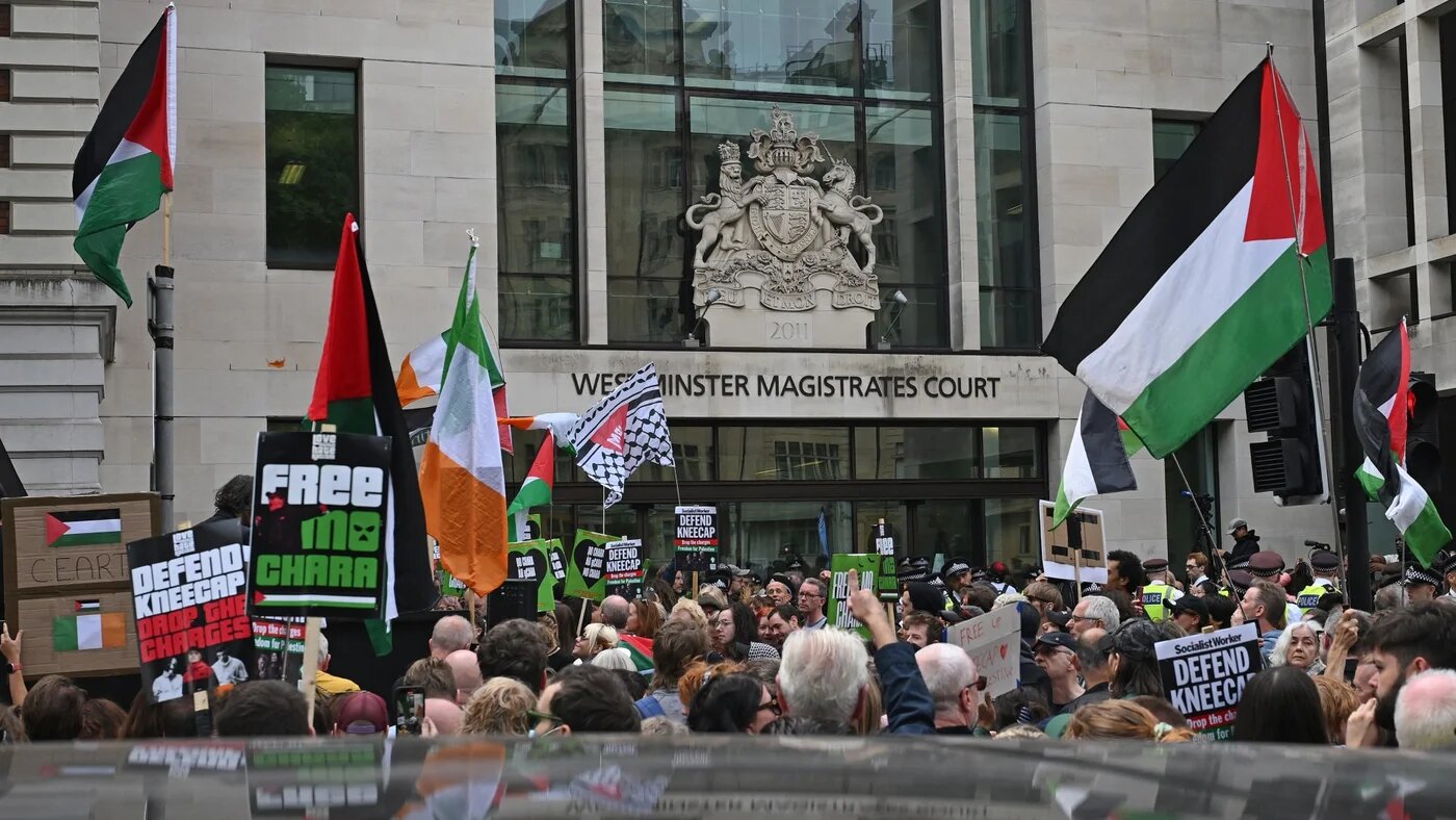 Supporters of the Irish band Kneecap fly Palestinian and Irish flags outside Westminster Magistrates' Courts in London on 20 August 2025 (AFP/Justin Tallis)