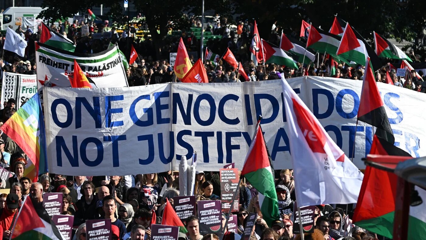 Participants display a banner reading 'One genocide does not justify another' at a demonstration in front of the Red City Hall in Berlin on 27 September 2025 (Ralf Hirschberger/AFP)