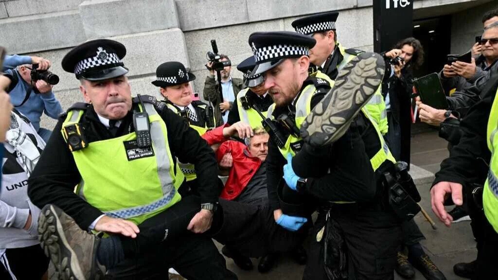 A protester is taken away by police officers at a "Lift The Ban" demonstration in support of the proscribed group Palestine Action, calling for the recently imposed ban to be lifted, in Trafalgar Square, central London, on October 4, 2025.
