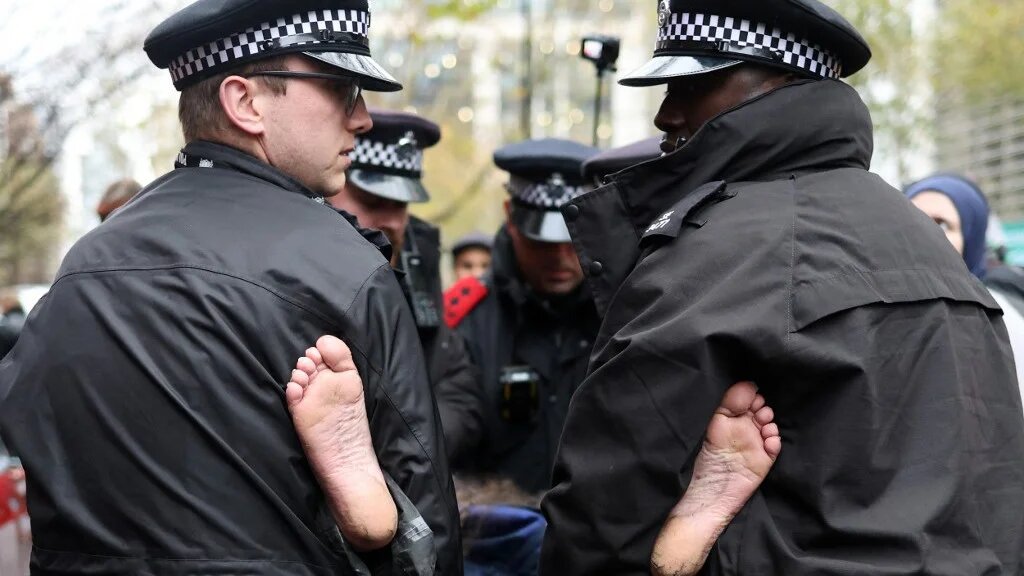 Police remove a protester during a demonstration in support of 'Defend Our Juries' and their campaign against the ban on Palestine Action, outside Britain's Home Office in London on 24 November 2025 (AFP)