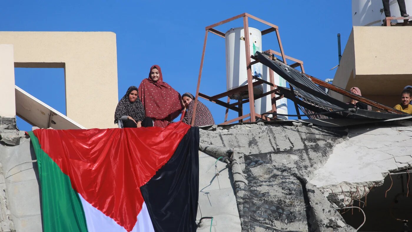 A Palestinian flag hangs from a building destroyed by Israeli bombardment in Khan Yunis, southern Gaza Strip, 2 December 2025 (Bashar Taleb/AFP)