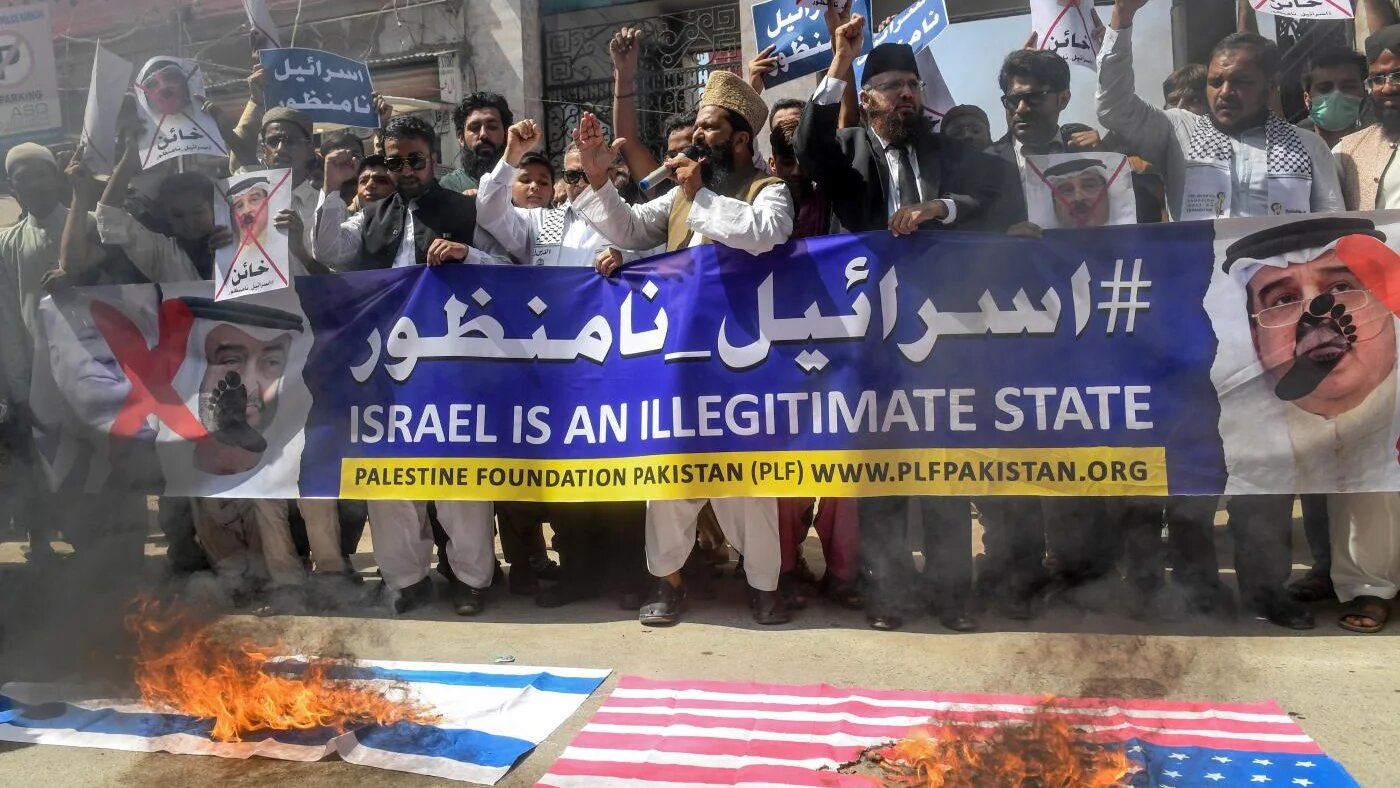 Des drapeaux israélien et américain sont brûlés au cours d’une manifestation contre la normalisation dans la ville portuaire de Karachi, au Pakistan (AFP)