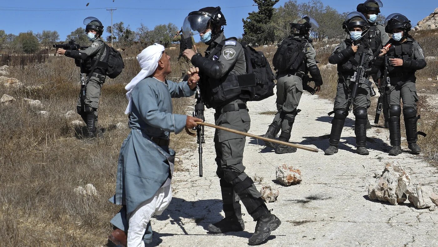 A Palestinian man confronts a member of the Israeli security forces 