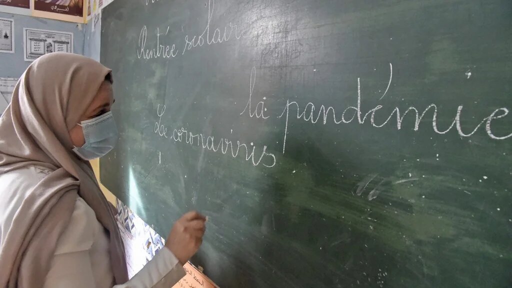 Une institutrice écrit son cours en français au tableau, dans une école algérienne, en octobre 2021 (AFP/Ryad Kramdi)