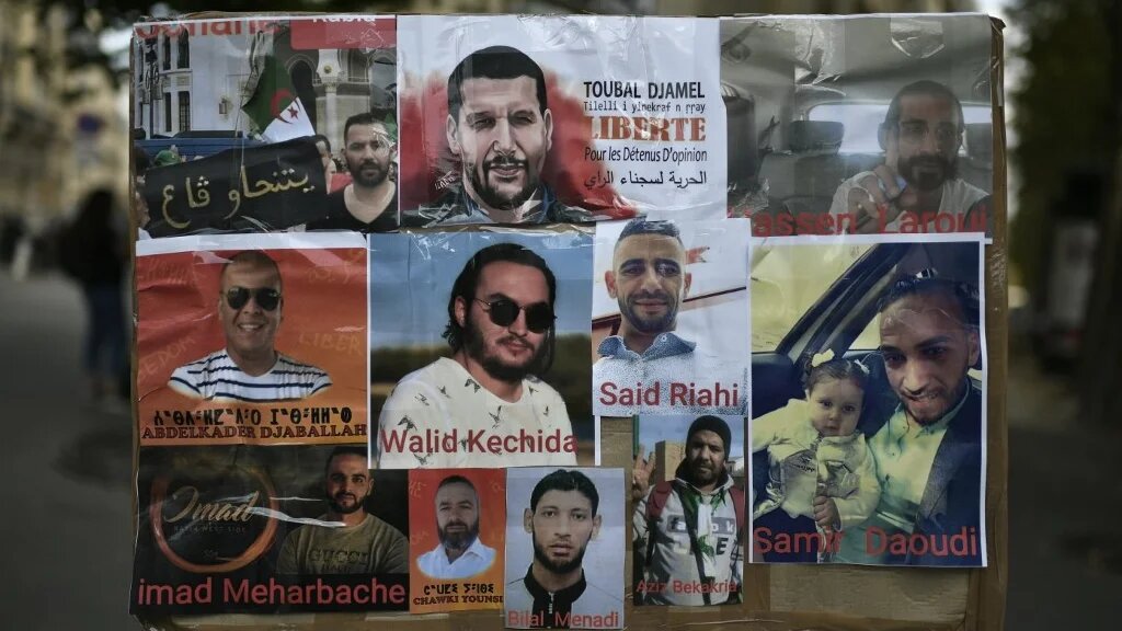 Une photo prise le 12 août 2020 montre des portraits de détenus algériens lors d’une manifestation à Paris devant l’ambassade d’Algérie (AFP)