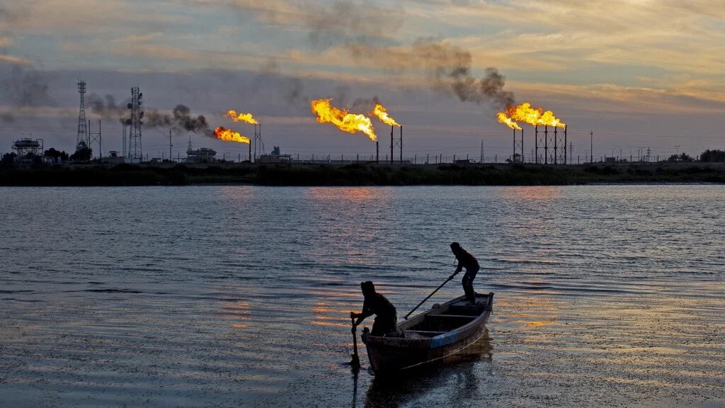 Des pêcheurs irakiens naviguent devant le champ de Nahr Bin Omar, au nord du port de Bassorah, dans le sud de l’Irak, le 21 janvier 2021 (AFP/Hussein Faleh)