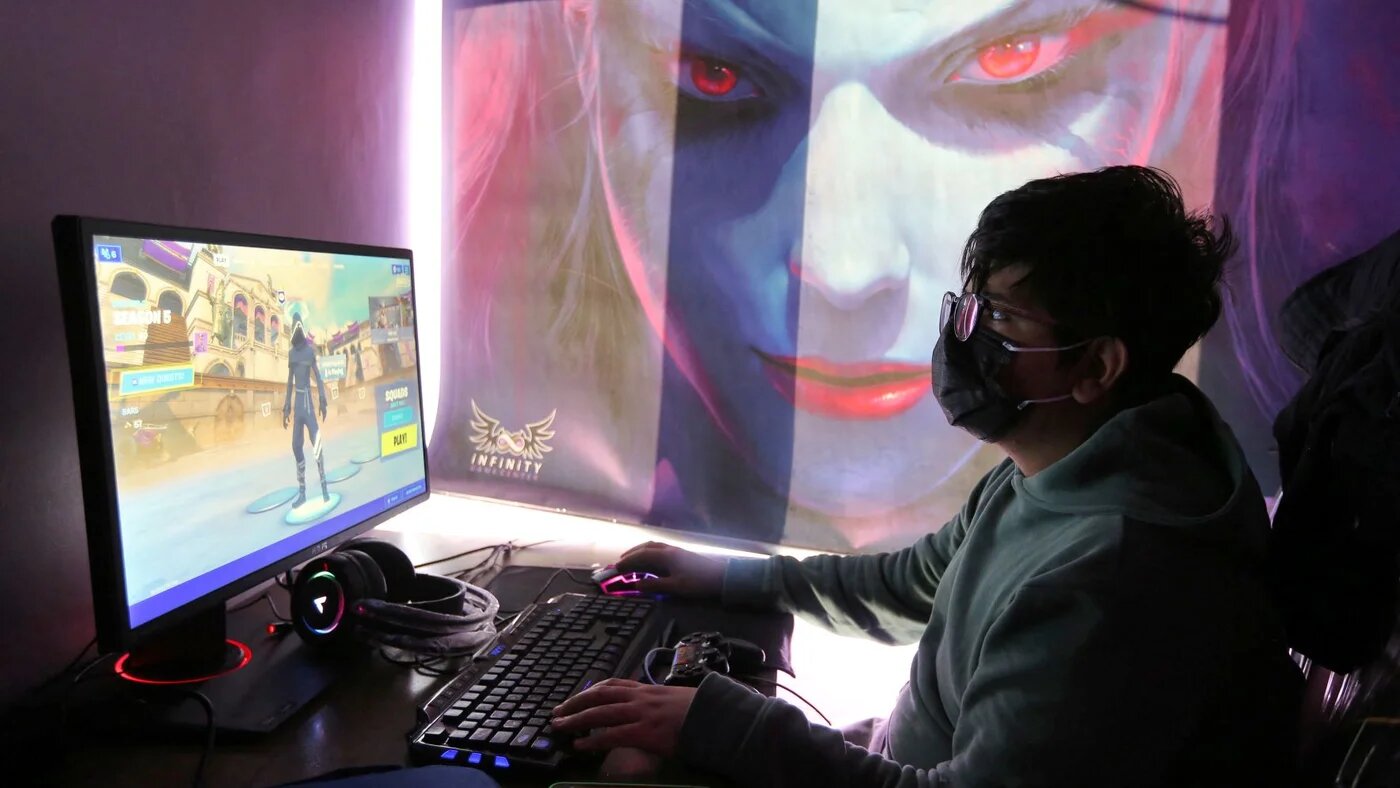 A youth plays an online multiplayer game at an internet cafe in Iran's capital Tehran on January 24, 2021 (AFP)