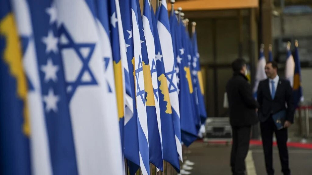 Kosovo's government officials stand in front of Kosovo's and Israel's flags displayed during a ceremony at the headquarters of the Foreign Ministry in Pristina on February 1, 2021 (AFP)