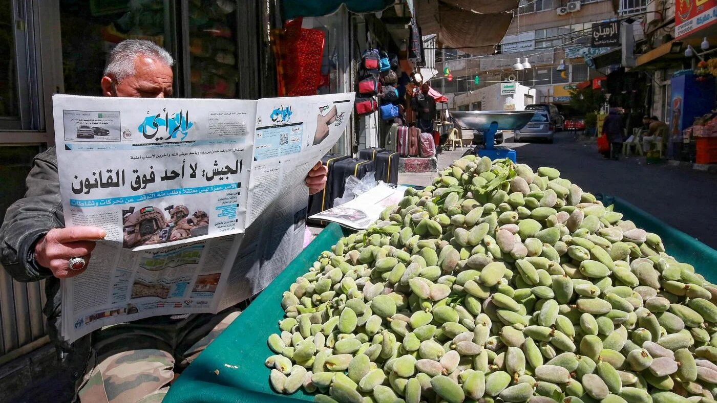 Un vendeur ambulant jordanien lit un journal local à Amman, le 4 avril 2021 (AFP)