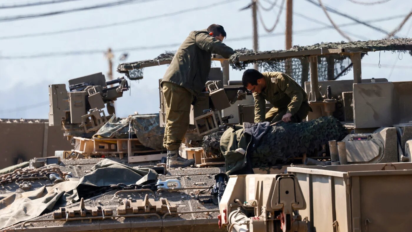 Israeli soldiers arrange their equipment on top of a tank in the Upper Galilee near the Lebanon border on 2 March 2026 (AFP/Jalaa Marey)
