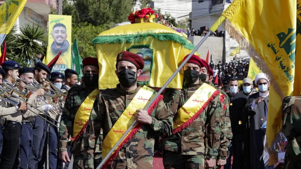 Des membres du Hezbollah portent le cercueil d’un des leurs, Mohamad Kassem Tahan, tué un jour plus tôt par des tirs israéliens à la frontière avec le Liban lors d’une manifestation contre l’offensive israélienne contre la bande de Gaza, le 15 mai 2021 (AFP/Anwar Amro)