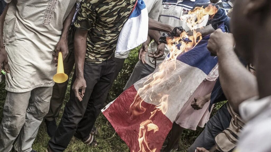 Des manifestants brûlent le drapeau tricolore lors d’une manifestation antifrançaise à Bamako, le 27 mai 2021 (AFP/Michele Cattani) 