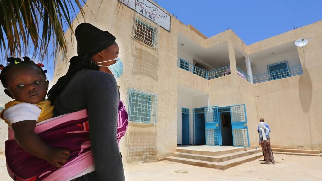 Aïcha, qui est venue de Guinée, arrive avec sa fille au centre de formation pour migrants de Médenine, au sud de la Tunisie, le 14 juin 2021 (AFP/Fathi Nasri)