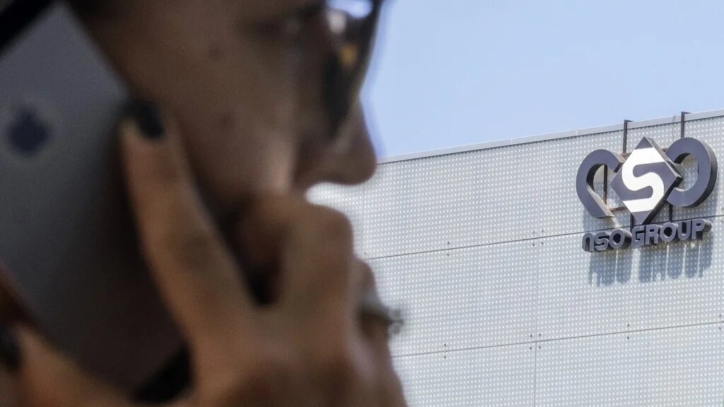 Une Israélienne se sert de son iPhone en face du bâtiment abritant la firme israélienne NSO Group, le 28 août 2016 à Herzliya, dans le district de Tel Aviv (AFP)