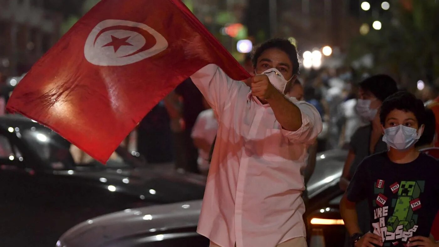 À Tunis le 25 juillet 2021, des gens célèbrent la décision du président Kais Saied de suspendre le Parlement et de limoger son chef du gouvernement après une journée de manifestations nationales (AFP)