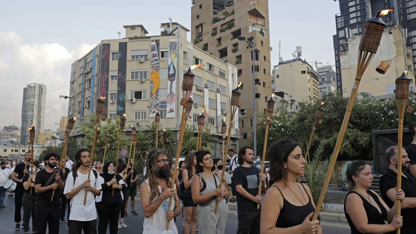 Protesters march with burning torches in Beirut