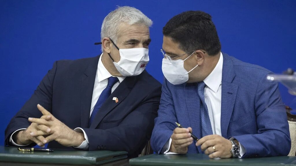 Yaïr Lapid et Nasser Bourita lors de la signatures de documents, le 11 août 2021 à Rabat (AFP/Fadel Senna)