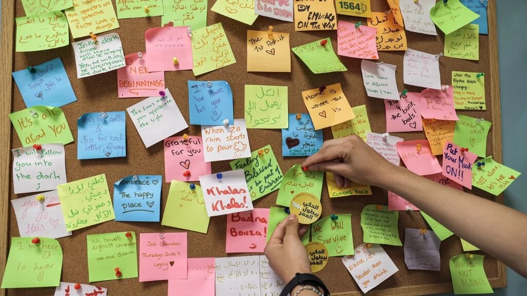 Une femme place une note sur un post-it dans les bureaux de l’ONG Embrace qui gère un numéro vert de prévention du suicide, à Beyrouth, le 1er septembre 2021 (AFP/Anwar Amro)