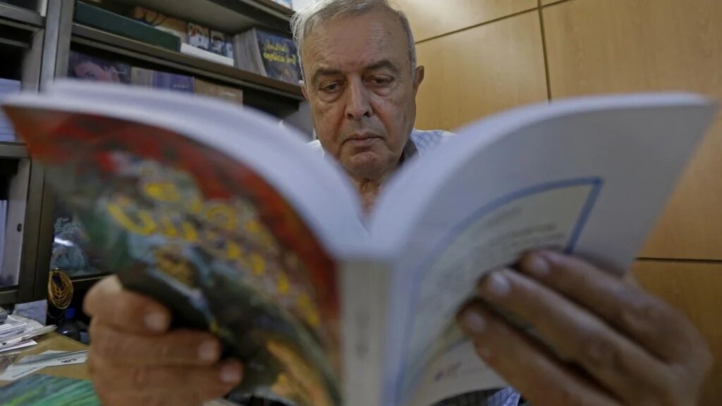 Khalil Haddad, qui travaille à la libraire et maison d’édition Dar Oussama, à Damas, consulte un ouvrage (AFP/Louai Beshara)