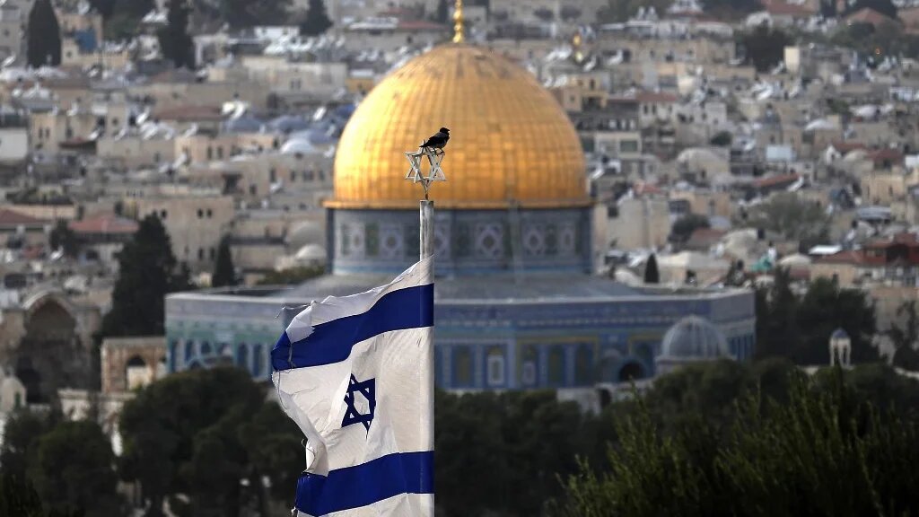 A picture of the Israeli flag with al-Aqsa Mosque seen in the background taken in occupied East Jerusalem on 1 November 2021 (AFP)