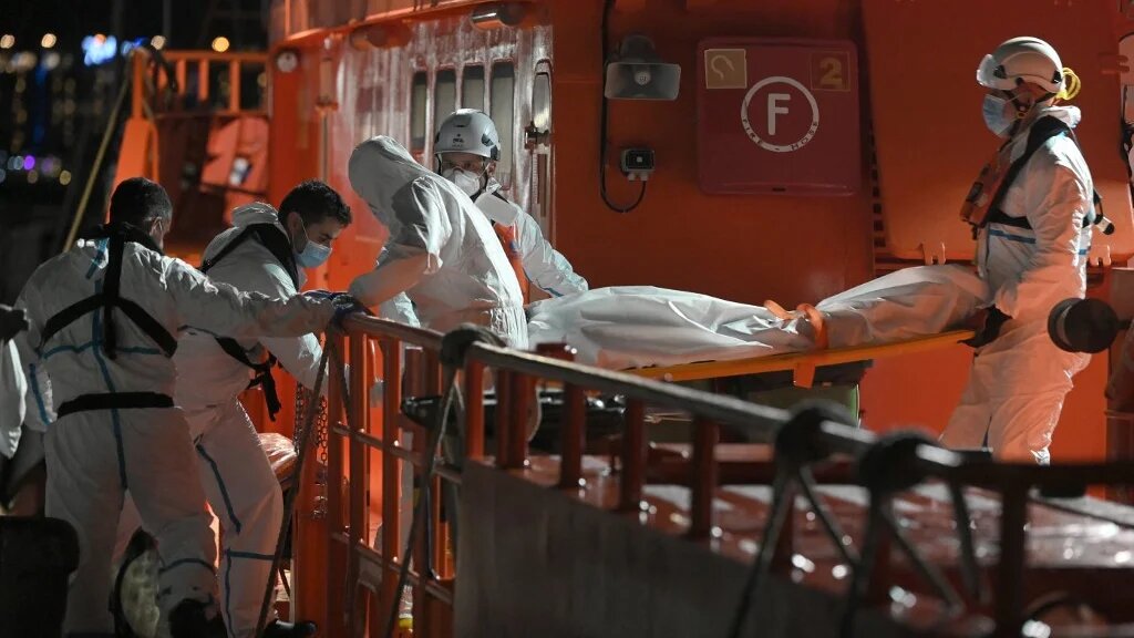 Des urgentistes espagnols débarquent le corps d’un migrant décédé, dans le port d’Arguineguín, sur la côte de l'île de Gran Canaria, le 18 novembre 2021 (AFP/Lluis Gene)