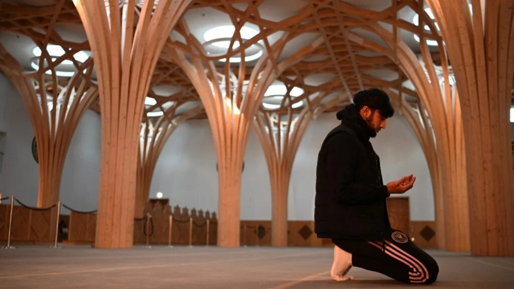 A worshipper prays inside Cambridge Central Mosque, in November 2021 (AFP)