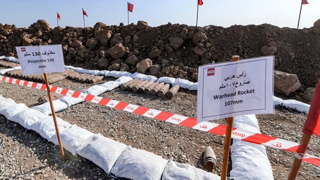 En attendant d’être désamorcées, les mines et explosifs trouvés sont déposés sur un terrain désertique (AFP/Zaid al-Obeidi)