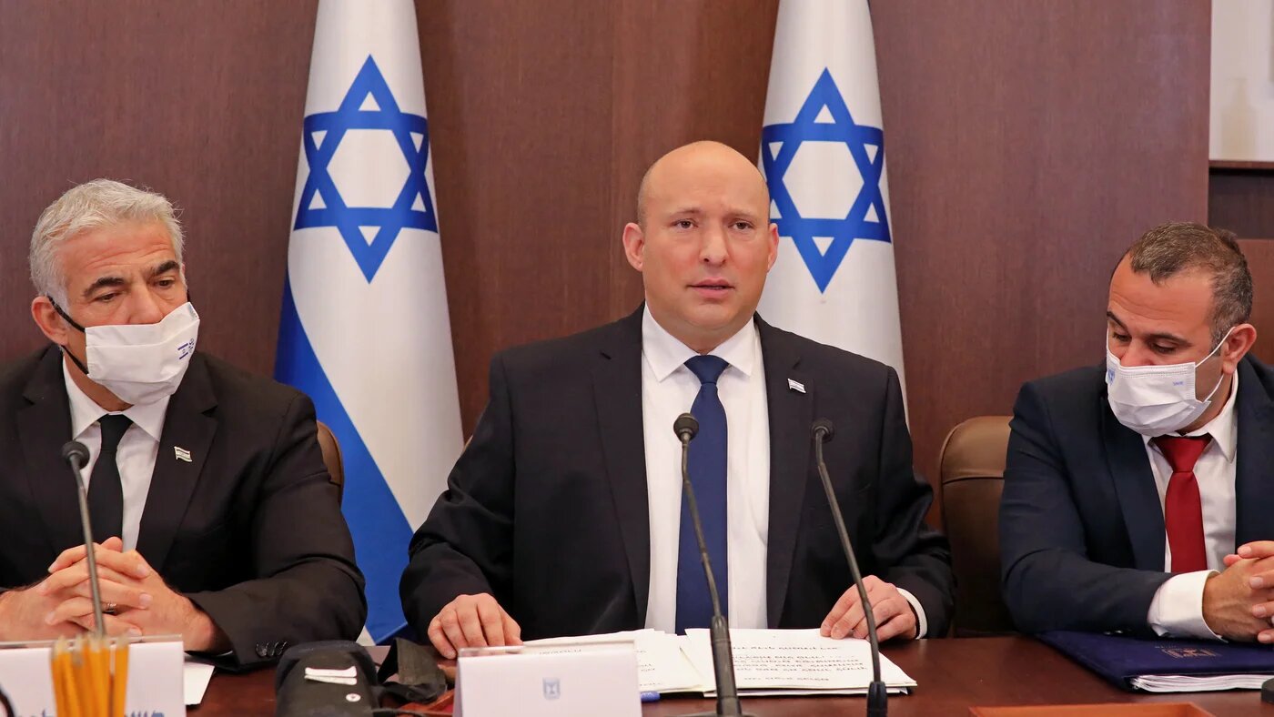Israeli Prime Minister Naftali Bennett (C) and Foreign Minister Yair Lapid (L)