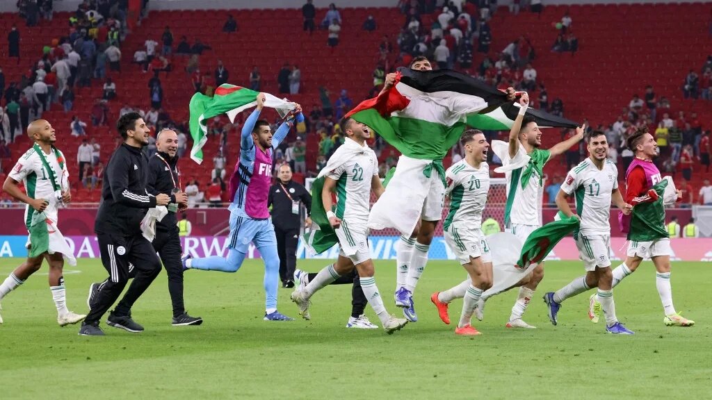  Les joueurs algériens arborent leur drapeau et celui de la Palestine après leur victoire face au Maroc à Doha, le 11 décembre 2021 (AFP / Karim Sahib)