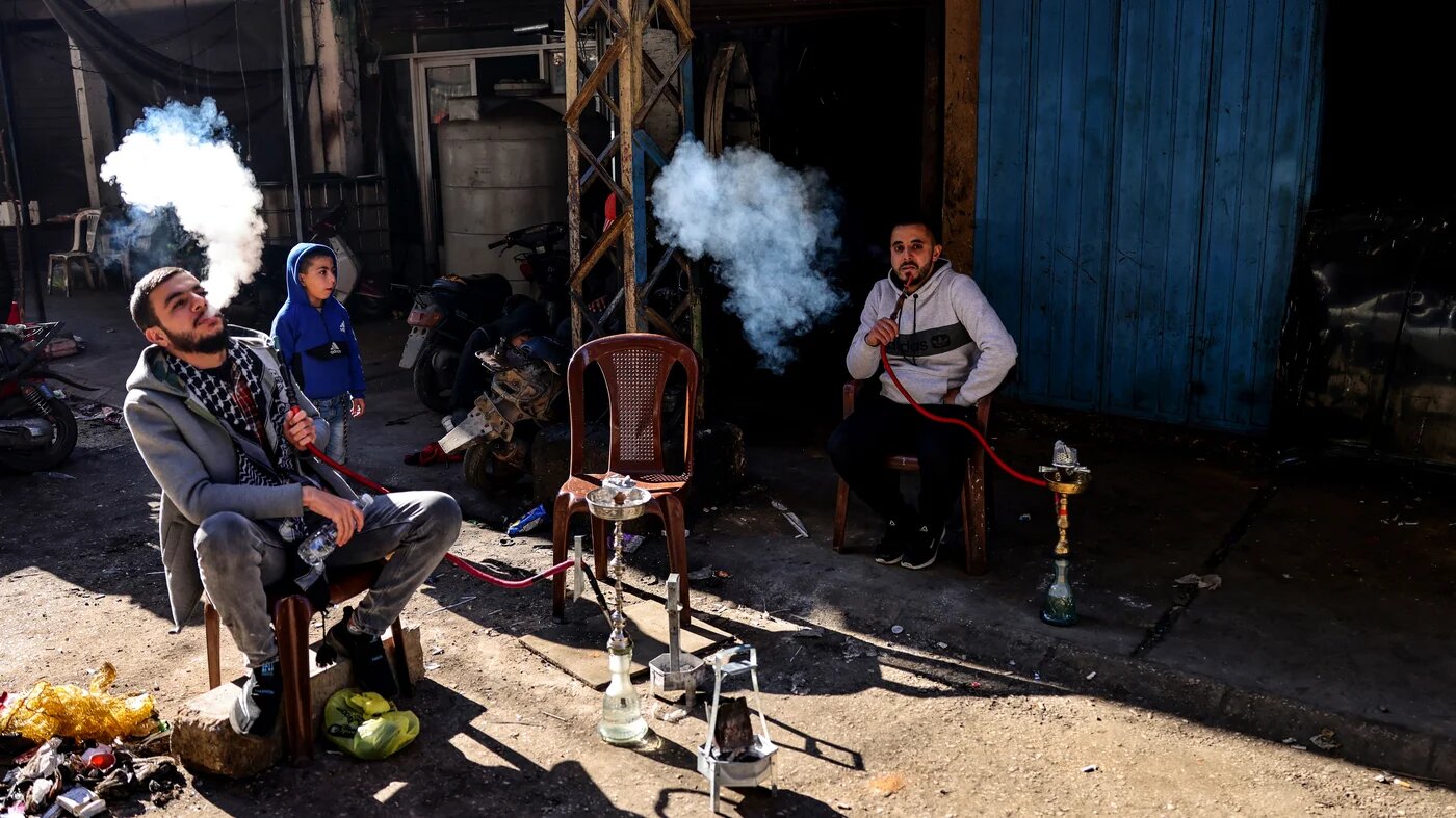 Des Libanais font une pause devant leur atelier dans une ruelle du quartier pauvre de Bab al-Tabbaneh, dans le nord de Tripoli (AFP/Joseph Eid)