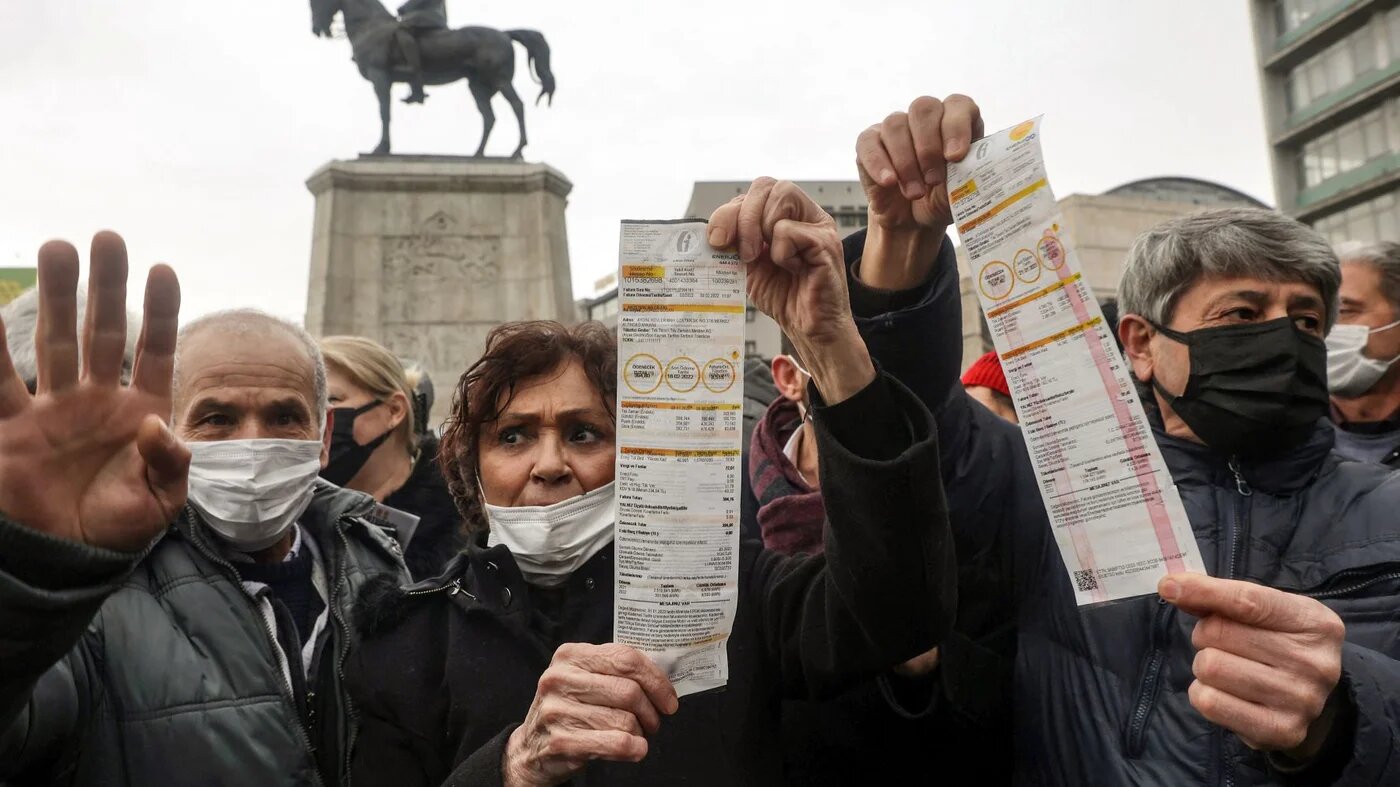 People hold up their electricity bills as they protest against high energy prices in Ankara on February 9, 2022, as temperatures plunged well below freezing and energy prices soared (AFP)