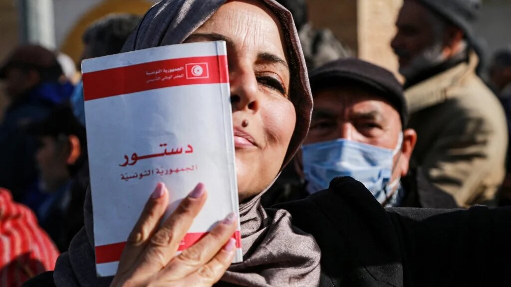 Une Tunisienne montre une copie de la Constitution, pendant une manifestation à l’appel du parti islamoconservateur Ennahdha, à Tunis, le 13 février 2022 (AFP/Anis Mili)