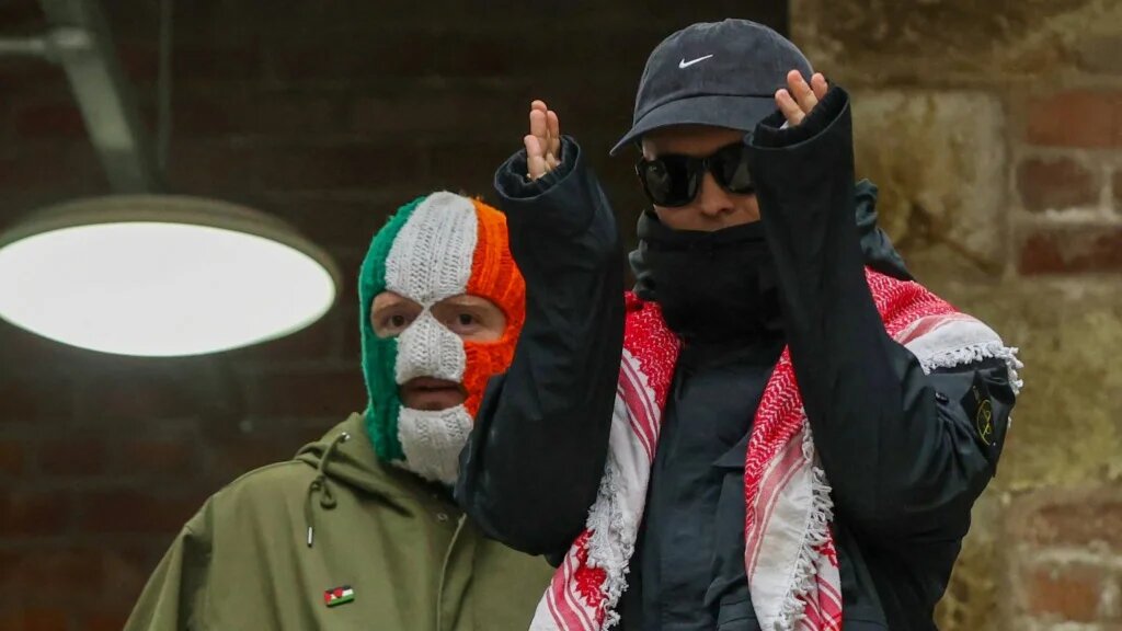 Liam O'Hanna (R), who performs under the stage name Mo Chara with punk-rap group Kneecap, arrives for a press conference with bandmate JJ O Dochartaigh (L), known as DJ Provaí, at the Conway Mill in Belfast on March 11, 2026. 