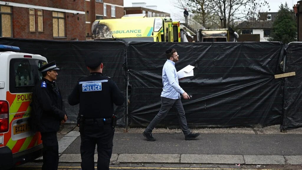 A member of the Jewish community passes the scene of an antisemitic arson attack in the Golders Green neighbourhood of north London, on March 24, 2026, an incident where volunteer ambulances run by a Jewish organisation were set on fire the previous night. 