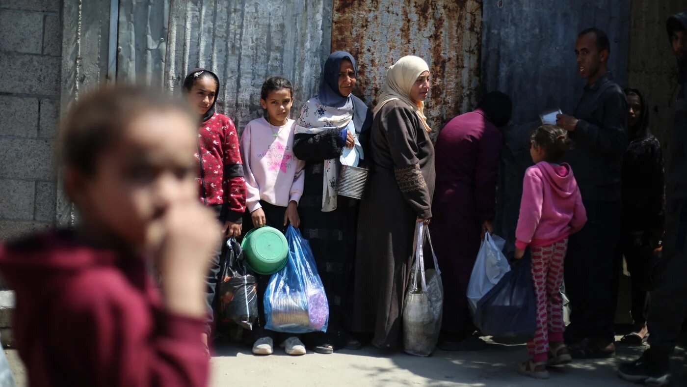 Displaced Palestinians wait to receive food from a charity kitchen at the Nuseirat refugee camp in the central Gaza Strip on 13 April 2026 (AFP/Eyad Baba)