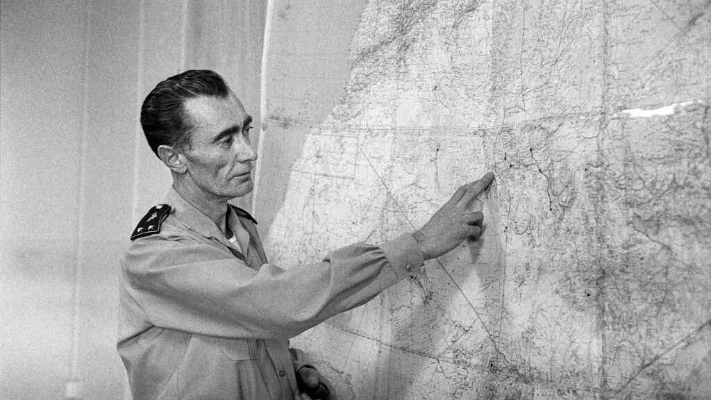 Photo prise à Reggane, dans le Sahara algérien, en décembre 1960 : le général Jean Thiry décrit aux journalistes l’explosion, le 27 décembre 1960, de la troisième bombe atomique française lors de l’opération dite « Gerboise rouge » (AFP)