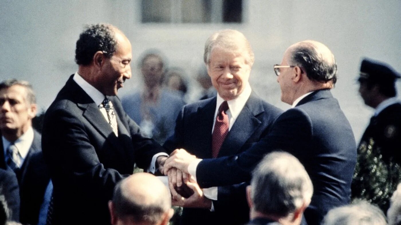 Le président américain Jimmy Carter félicite Anouar al-Sadate et le Premier ministre israélien Menahem Begin dans une poignée de main à trois, le 26 mars 1979 sur la pelouse nord de la Maison-Blanche, après avoir signé le traité de paix historique parrainé par les États-Unis entre Israël et l’Égypte. En 1978, Israël et l’Égypte avaient scellé un accord promettant la paix et la sécurité aux peuples du Moyen-Orient, les accords de Camp David. (AFP)