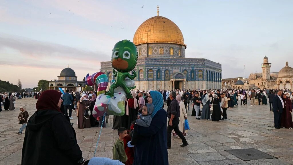 Muslim devotees with their children gather at the Al-Aqsa Mosque compound in Jerusalem on May 27, 2026, to mark the start of Eid al-Adha, the Feast of Sacrifice.