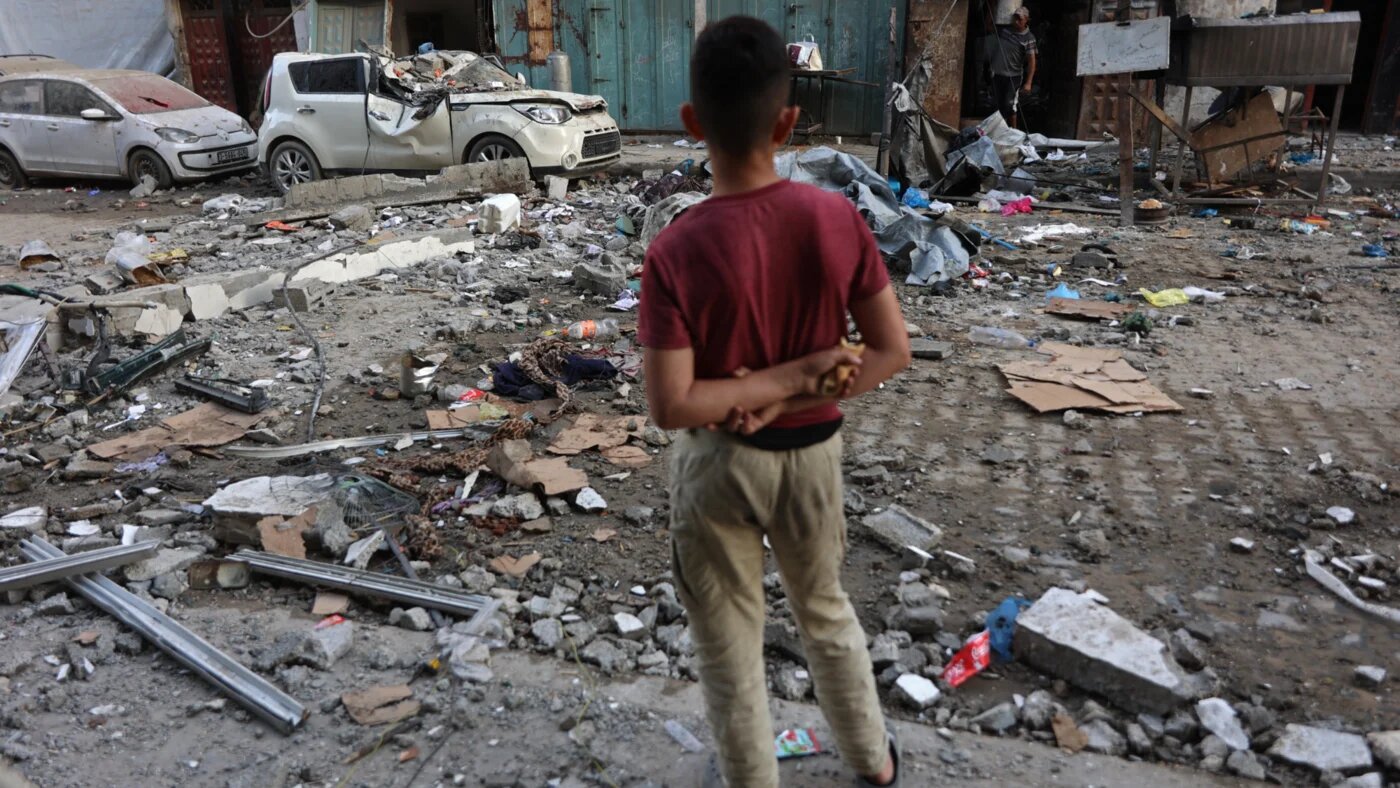 A Palestinian boy looks at the rubble of residential buildings and a damaged car after an Israeli strike in Gaza City on 4 June 2026 (Omar al-Qattaa/AFP)