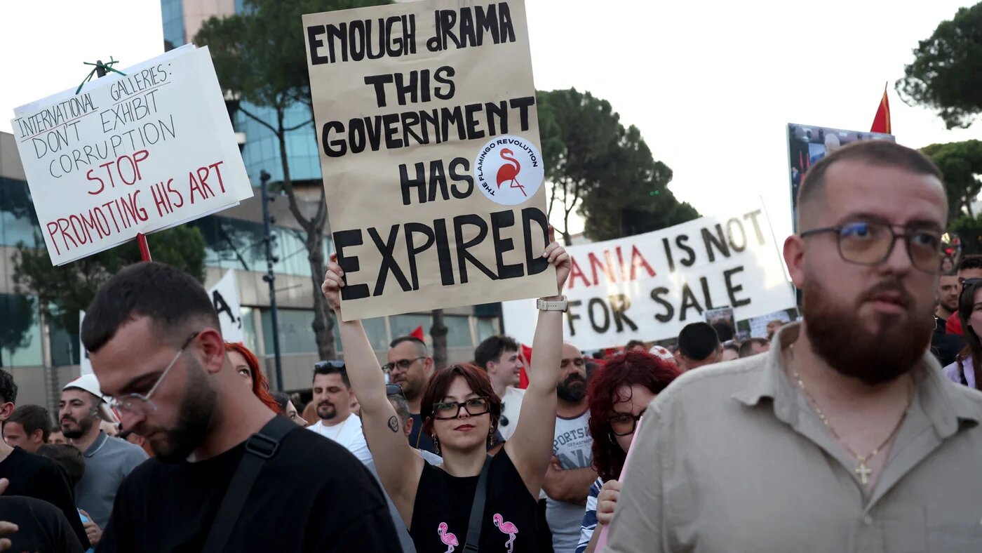 Protesters in Tirana hold placards reading "Enough Rama - This government has expired" and "Stop promoting his art" outside the prime minister's office on 12 June 2026 (Adnan Beci/AFP)